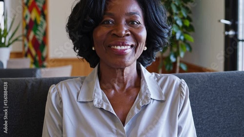 smiling middle-aged black woman in her 40s or 50s, smart casual, sofa