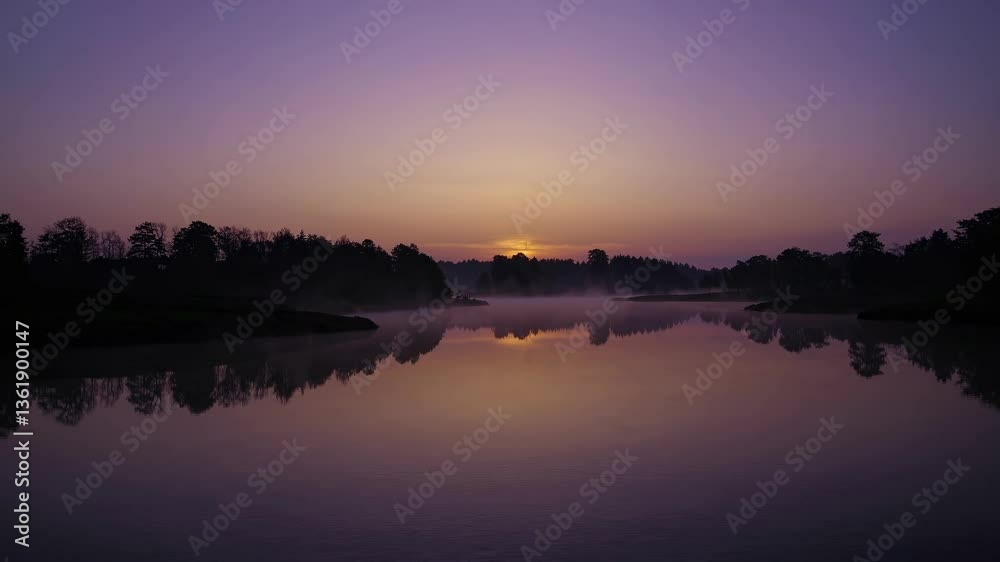 A serene twilight landscape video with a wide-angle view captures a calm lake reflecting the purple sky, framed by silhouetted trees. Live desktop wallpaper. A serene twilight landscape video with a wide-angle view captures a calm lake reflecting the purple sky, framed by silhouetted trees. Live desktop wallpaper.