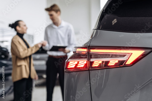 A customer at a car dealership consults with a salesperson, choosing a new vehicle. Concept: a trusting dialogue between the buyer and the consultant, the decision-making process for purchasing a car.