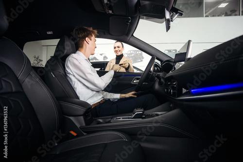 Foto A car sales manager shows a vehicle to a customer in a luxurious dealership