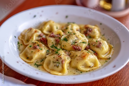 Close-up of agnolotti di borgo with creamy yellow sauce, meat chunks, fresh herbs. Concept of agnolotti di borgo showcases delicious piedmont stuffed pasta dumplings.