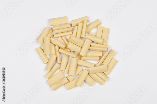 A pile of small brown paper pieces lies on a white background