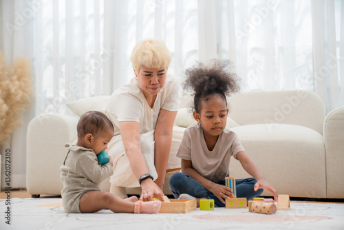 Children engaging in playtime with blocks under the guidance of a caregiver in a cozy living room setting