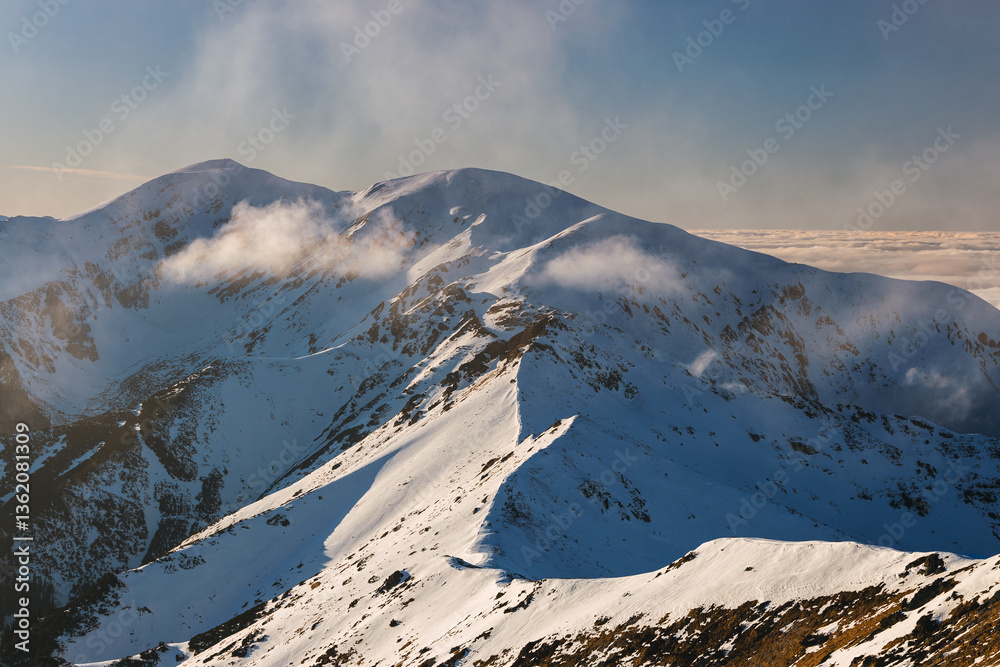 Snow-covered peaks of the Tatra Mountains with Kasprowy Wierch in winter. Stunning alpine scenery, perfect for skiing, hiking, and photography. Cold, crisp air and breathtaking views