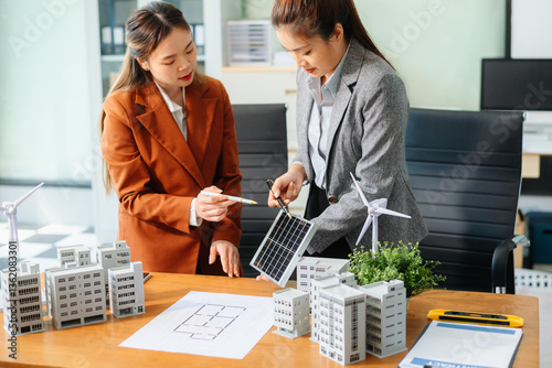 Professionals for a greener future. Showcasing renewable energy solutions with solar panels, wind turbines, and a model house.
