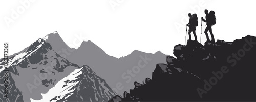 Silhouetted hikers on rocky mountain peak overlooking snow-capped range.