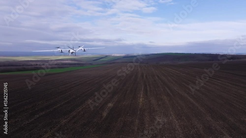 The white high-speed drone films and scans the surface of open fields. The drone makes aerial recordings of the surface of undeveloped land.Innovations and technologies in real estate and construction