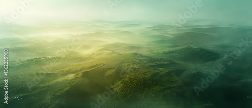 Aerial view of lush green hills shrouded in mist, showcasing serene nature and distant mountains