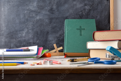 Religion class with desk with tools, Bible and blackboard
