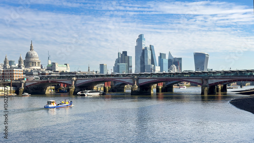 Blackfriars Bridge and the Rover Thames, with St Pauls Cathedral and the modern skyscrapers of the city of London in the distance.