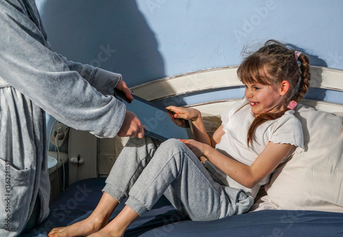 young girl angry resists as an adult tries to take her tablet, depicting a screen time struggle, digital addiction