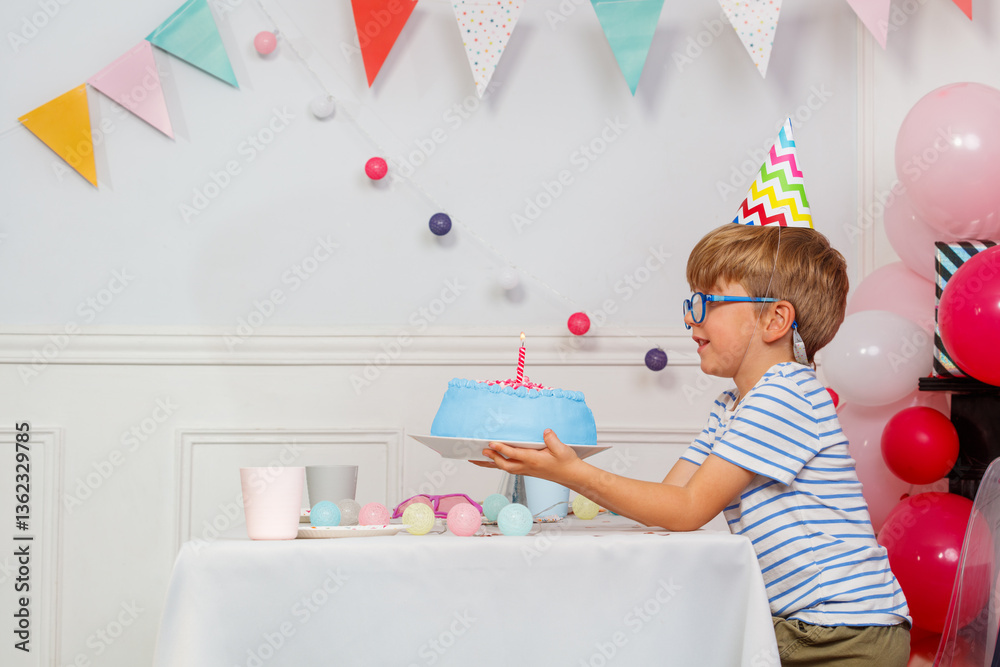 Happy boy kid in glasses celebrate his birthday hold blue cake