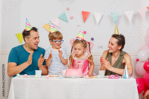 Obraz na płótnie Happy family celebrates child's birthday with pink icing cake w salonie