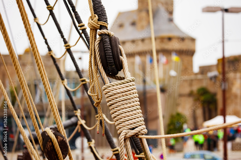 Close-up of ship ropes with blurry historic tower in Saint Malo