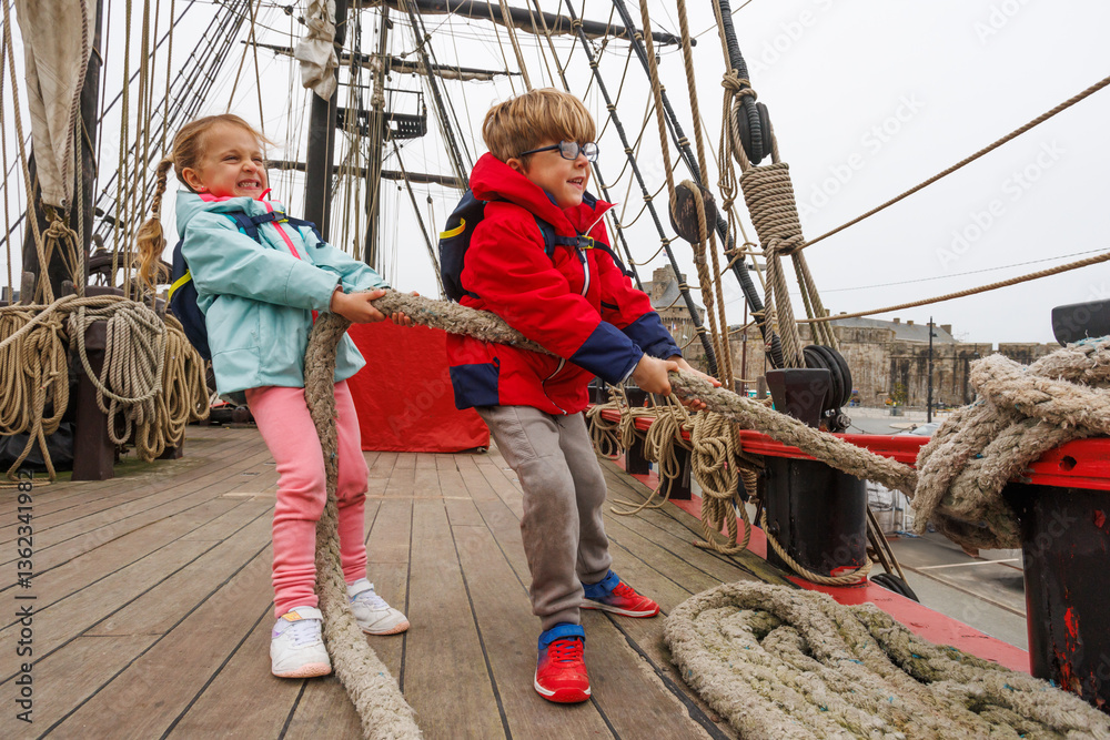 Kids joyfully pulling a rope on ship deck adventure attraction
