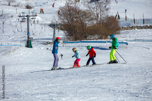 Group of three kids receive instruction from their ski teacher