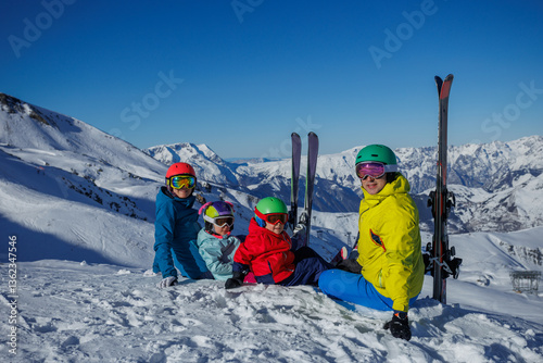 Colorful skiers rest, enjoying the snow and sun