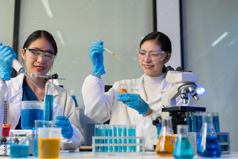 Fototapeta premium Scientist analyzing and dropping a sample into a glassware.