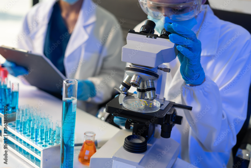 Scientist analyzing and dropping a sample into a glassware. Scientist analyzing and dropping a sample into a glassware.