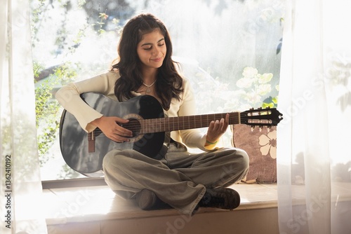 teenage girl practices guitar 