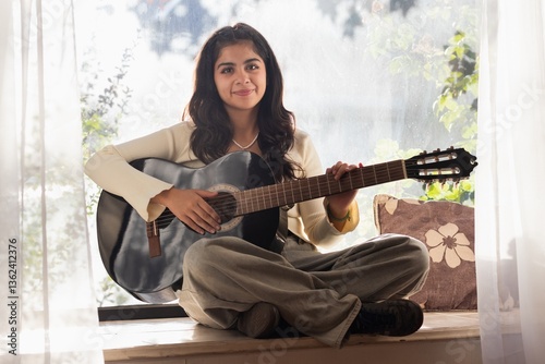 woman practices guitar and smiles 