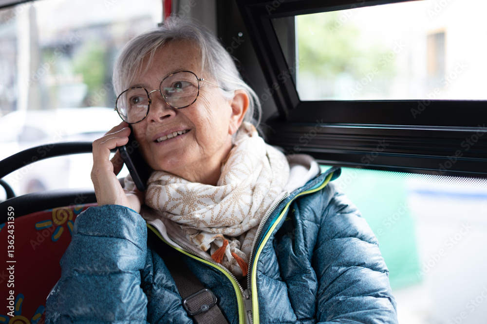 Portrait of a smiling senior woman sitting on the passenger seat during a sightseeing tour on a bus while talking at her cell phone