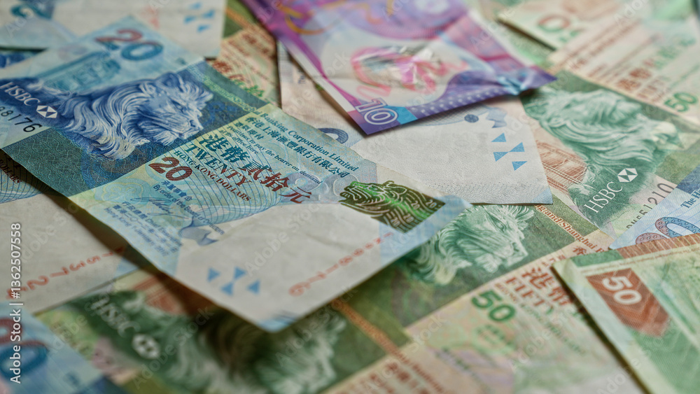 Obraz premium Hong kong dollar banknotes scattered on a flat surface, displaying various denominations and intricate designs.