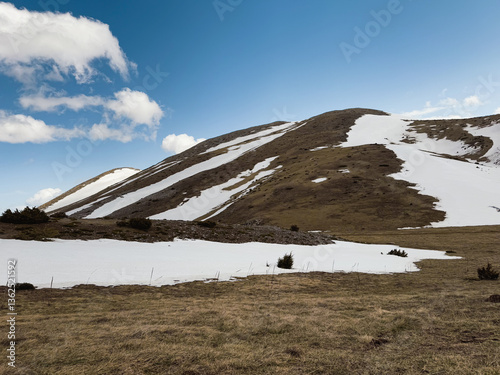 Hikers navigate the stunning terrain of Mavrovo in Galichnik, North Macedonia, surrounded by snow-capped hills and clear blue skies. A perfect spot for trekking and nature lovers photo