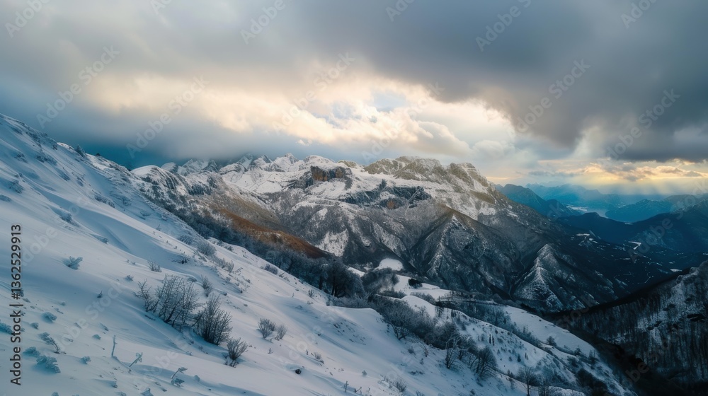 Obraz premium Majestic frozen mountain peaks of Montenegro under dramatic winter clouds at sunset