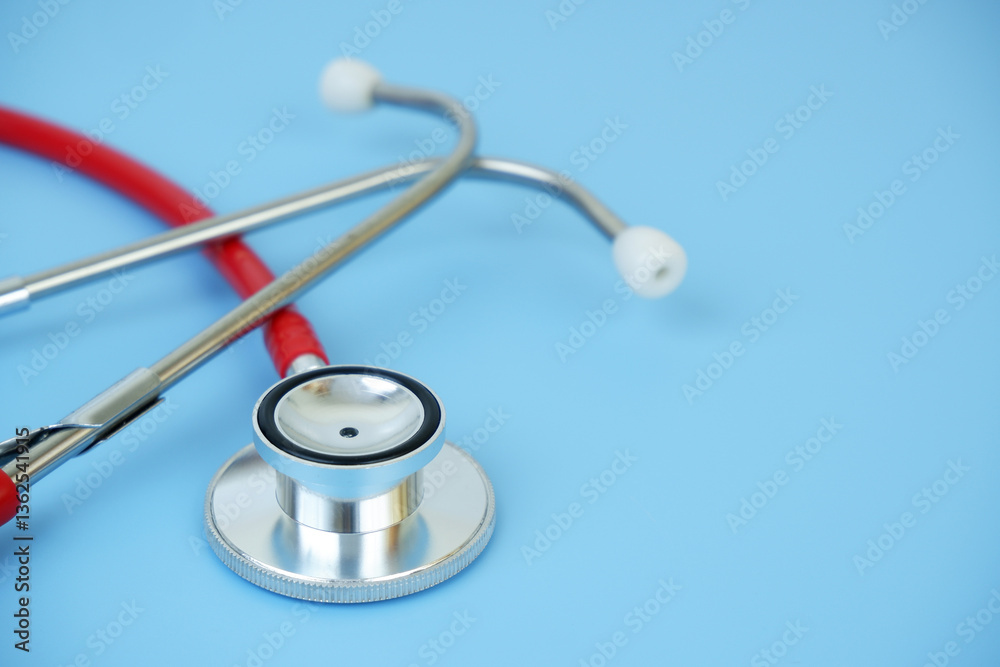 Red stethoscope on blue background close up. Copy space for text. Red stethoscope on blue background close up. Copy space for text.