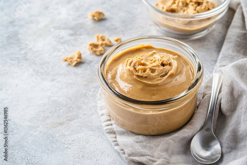 Creamy Peanut Butter in a Glass Jar with Spoon

