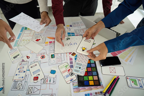 Design Process and Creative Input. Team examining design elements together to enhance digital user experience.