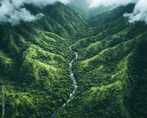 Lush mountains meet a river below wispy clouds