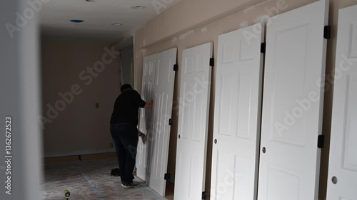 A man finally wipes the door before installing it.