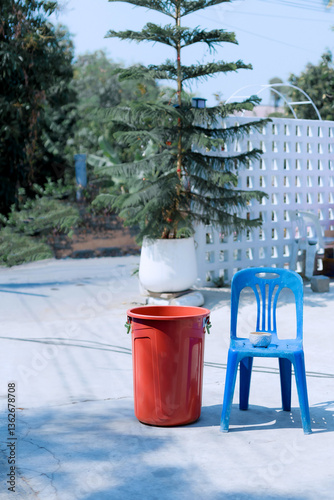 Blue plastic chairs and red plastic water buckets are placed outdoors.
