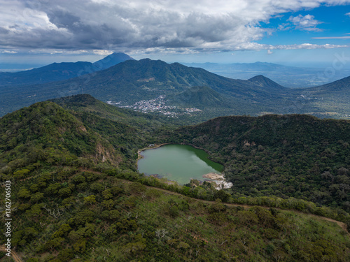Aerial drone panorama of Laguna de Alegria - small lake with green water surrounded by lush green forest overgrown inactive volcano crater located in San Vicente province, El Salvador, Central America