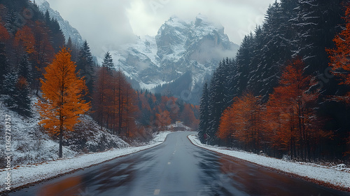 Road into mountains Autumn trees with snow meet forest and snow-capped peaks under gray sky