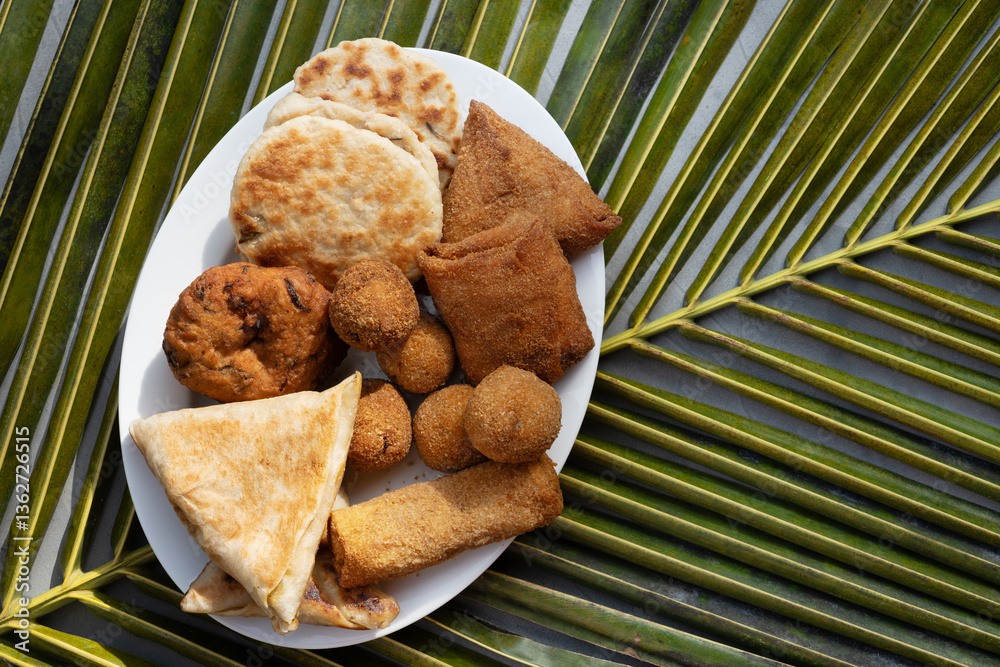 Authentic Sri Lankan different street food, short eats. Vegetable roti, coconut roti, cutlets, mutton rolls on white plate. View from above. Copy space.