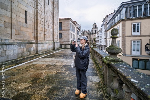 Tourist taking pictures of orense cathedral from a balcony