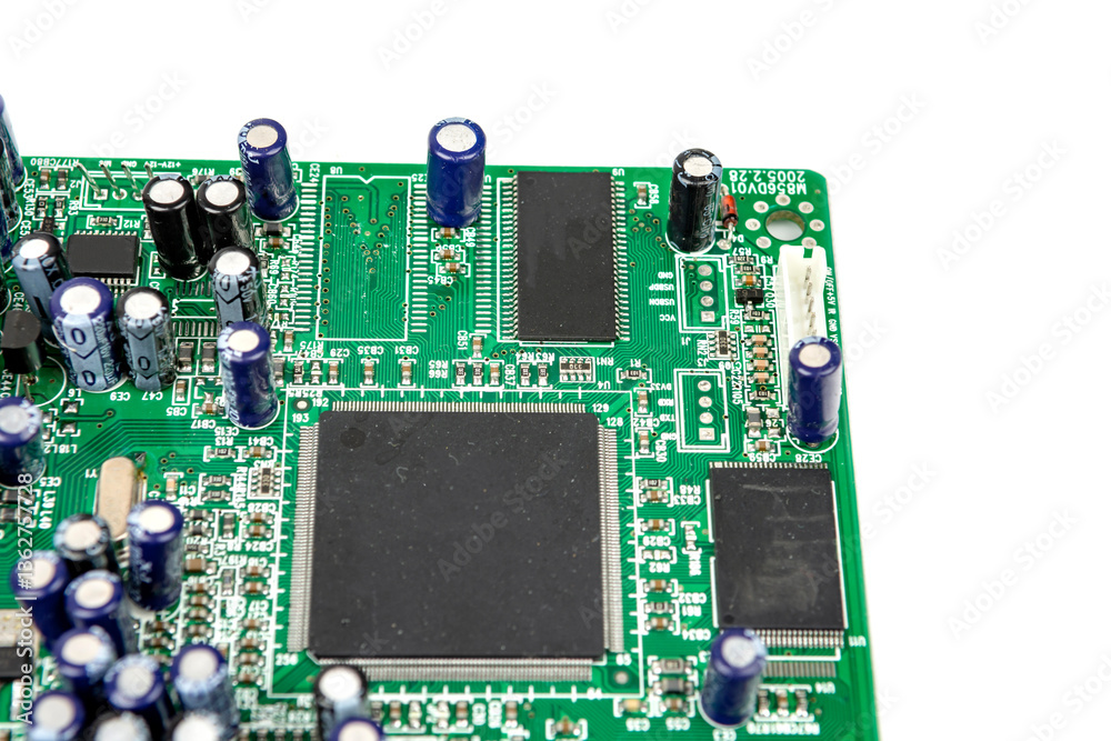 A close-up of the processor microchip surrounded by other electrical components on a green circuit board. Also on the board is a row of several speaker connectors. A close-up of the processor microchip surrounded by other electrical components on a green circuit board. Also on the board is a row of several speaker connectors.
