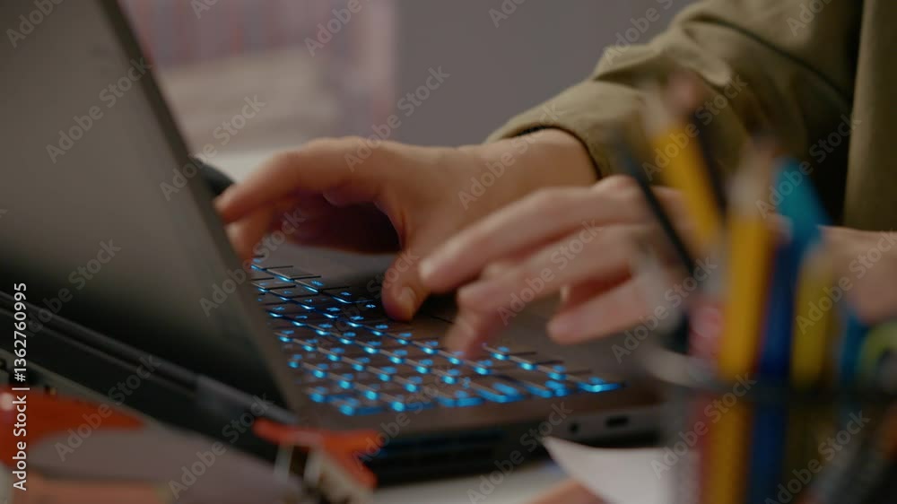 Woman hands typing efficiently on backlit laptop keyboard, focusing intently while writing detailed email or comprehensive business report at modern workspace