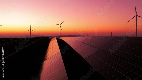 Green energy reduce carbon emissions and makes earth cleaner and more ecological.Clean and environmental.Photovoltaic power station and wind turbines at sunset.Windmill turbines generating energy.