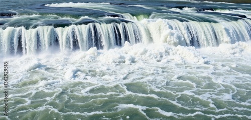 A powerful waterfall cascades into a churning, whitewater river, cascade, turbulence