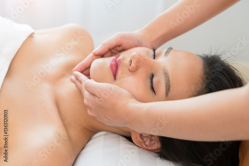 Wallpaper Mural Facial massage treatment. Asian woman with closed eyes lying on back and receiving face lifting massage in spa salon Torontodigital.ca