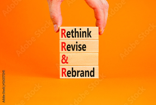 Rethink revise rebrand symbol. Concept word Rethink Revise and Rebrand on beautiful wooden blocks. Beautiful orange background. Business brand rethink revise rebrand concept. Copy space.