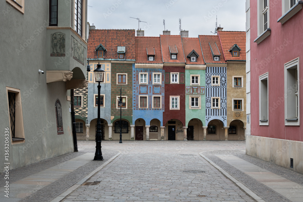 Fototapeta premium Colorful medieval merchant houses with arches on the old market square, Stare Rynek in the city centre of Poznan, Poland. Wonderful must-see touristic spot. Old houses with different colors, architect