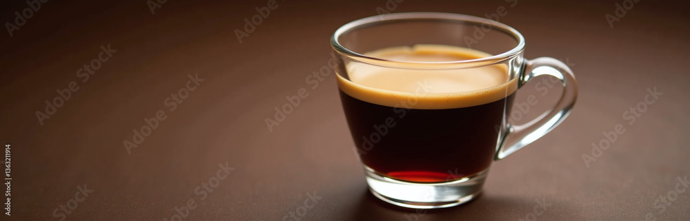 A Shot Of Espresso Is Artfully Presented In A Delicate Clear Glass On A Richly Toned Brown Background. A Shot Of Espresso Is Artfully Presented In A Delicate Clear Glass On A Richly Toned Brown Background.