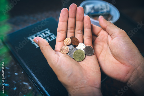 Coins with Holy Bible, a closeup, Christian biblical concept of tithing, Biblical concept of Christian offering