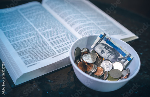 Coins with Holy Bible, a closeup, Christian biblical concept of tithing, Biblical concept of Christian offering