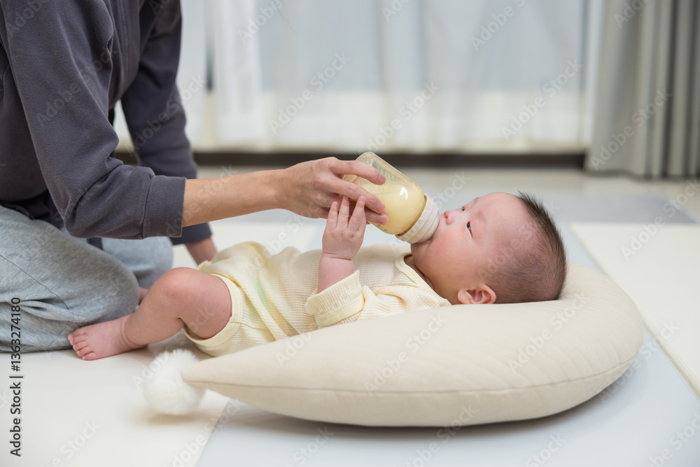Mother feeding baby milk at home